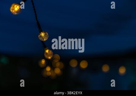 Light garland, small solar-powered LED bulbs on a string, garden decoration for the terrace, hanging lights, Stock Photo