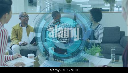 Discussing project details, five office colleagues sitting in modern lounge with papers and tablets Stock Photo