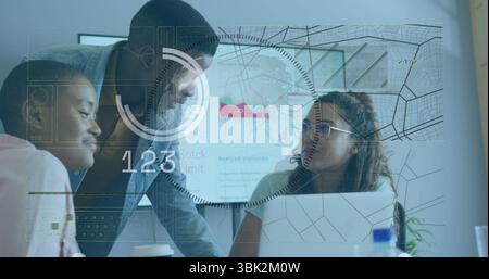 Analyzing data three coworkers leaning over office table, using laptop and floating charts and map Stock Photo