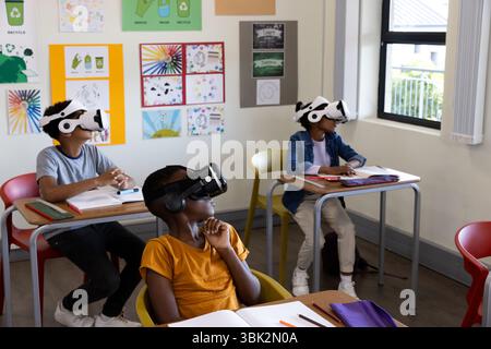 Diverse students in classroom using VR headsets for interactive learning experience, at school Stock Photo