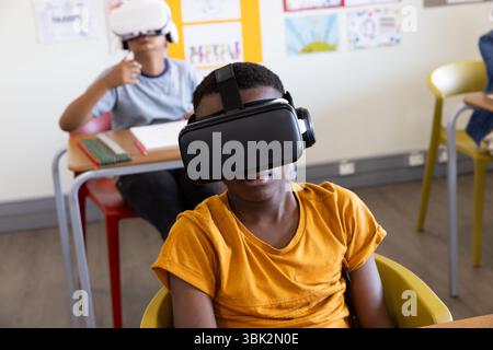 Diverse students in classroom using VR headsets, exploring virtual reality learning, at school Stock Photo