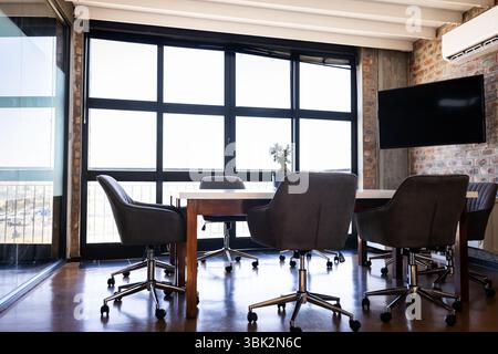 Modern office conference room with empty chairs around large wooden table, copy space Stock Photo