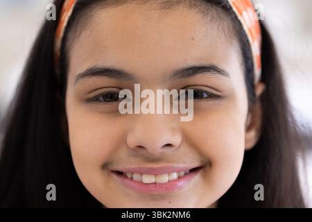 Smiling girl with headband enjoying school day, feeling happy and confident Stock Photo