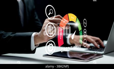 Businessman using a laptop while touching the icon of his credit score on the tablet screen. Technology innovation on a virtual screen. Concept of cre Stock Photo