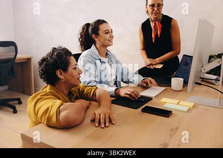 A diverse team of professionals enthusiastically collaborates in a modern office environment. The scene captures a professional small business atmosph Stock Photo