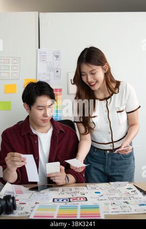Innovative Design Discussion. Young professionals engaged in a collaborative project review in a modern office. Stock Photo