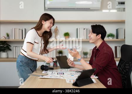Engaging Design Discussion. Young professionals collaborating on UX UI projects in a bright office. Stock Photo