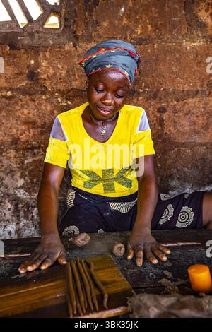 Woman working in a workshop where peanuts are transformed into klui klui sticks in central Benin Stock Photo
