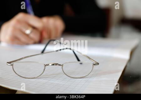Young woman writing in a notebook. Homework. Stock Photo