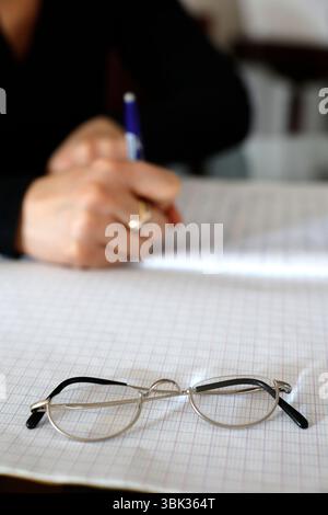 Young woman writing in a notebook. Homework. Stock Photo