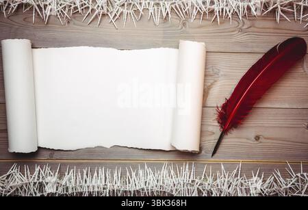 Flat design featuring blank parchment scroll on wooden table with red quill pen and white strands Stock Photo