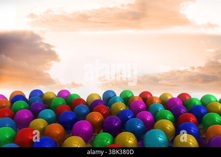 Dense cluster of glossy multicolored spheres is sitting on ground in 3D render under sunlit clouds Stock Photo