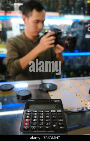 Photo store. Customer buying used photo equipment. Ho Chi Minh city. Vietnam. Stock Photo