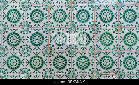 A pattern of traditional Portuguese azulejo tiles featuring green and white floral and geometric designs, showing classic artistry, Lisbon Stock Photo