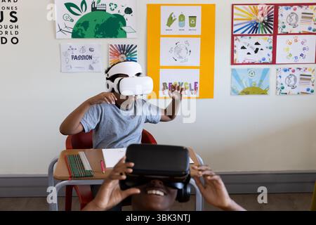 Diverse students using VR headsets in classroom, exploring virtual reality technology, at school Stock Photo
