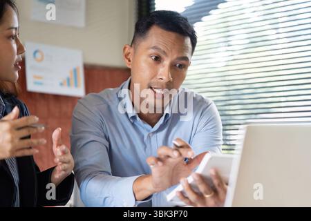 Collaborative Discussion. Business professionals strategizing over a laptop. Stock Photo