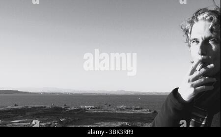 Smoking man on the sea coast in italy Stock Photo