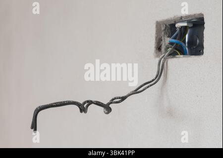 Closeup of exposed electrical wires in wall with partially installed electrical box Stock Photo