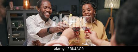 Website header shot of couple raising glasses in celebratory toast, enjoying pleasant conversation and laughter during festive family gathering at home Stock Photo