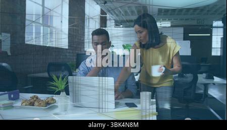 Collaborating coworkers discussing project details on laptop in open-plan office, with white mug Stock Photo