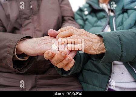 An elderly matrimony hands with rheumatoid arthritis Stock Photo