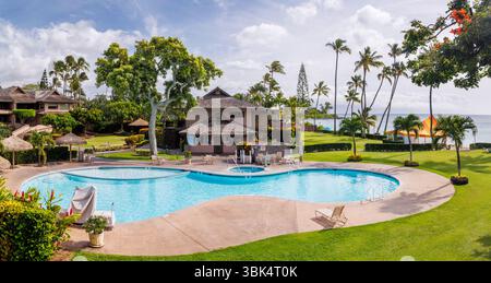 Luxury pool at a Hawaiian resort on a sunny day, surrounded by tropical greenery and blue skies Stock Photo