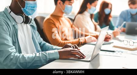 International people students wearing medical masks using laptop Stock Photo