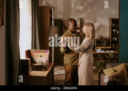Senior Multiethnic Couple Dancing Together and Sharing Romantic Moment Indoors Stock Photo
