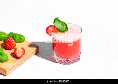 Refreshing Strawberry Basil Smash Cocktail, glass of blended strawberry drink on white background, copy space. Summer cold drink. Stock Photo