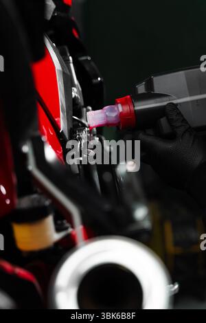 Motorcycle Oil Refill. Replacing engine oil in a sports motorcycle to ensure top performance and engine longevity. Precision oil fill operation on a r Stock Photo