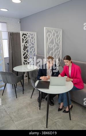 Colleagues are sitting at a laptop and discussing work.  Stock Photo
