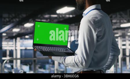 Data center programmers on industrial platform using green screen laptop, collaborating on tasks. Server hub workers visualizing large language model architecture using mockup notebook and PC Stock Photo