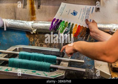 Colourist Marina Bahri in the dyeing workshop at the Terrade spinning mill. The dyeing process is usually based on a customer sample. The desired shades are created using three basic colours (in powder form) and keen observation. All recipes are based on experience, not written instructions. Rue de la Papeterie, Felletin, Nouvelle-Aquitaine, France Stock Photo