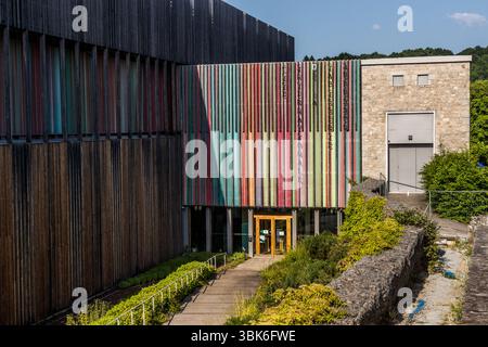 The striking building with the colourful façade of the Cité internationale de la tapisserie in Aubusson. The institution is a model project that preserves the traditional expertise of a UNESCO-recognised cultural technique, leads it into the future through targeted innovation and positions itself in an international network. Avenue de la République, Aubusson, Nouvelle-Aquitaine, France Stock Photo