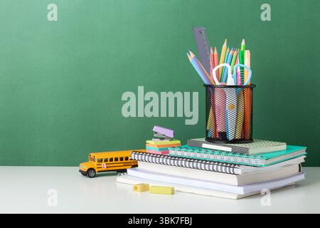 Colorful School Supplies Arranged on Desk With Green Background, chalkboard, back to school concept Stock Photo