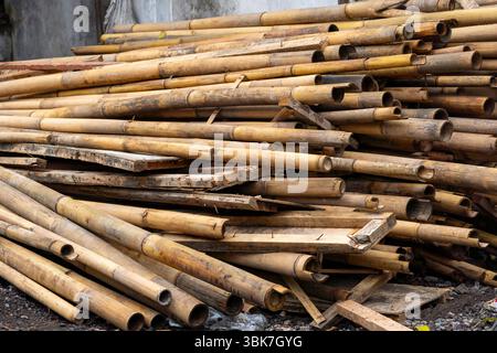 Pile of bamboo sticks and boards are stacked in a pile. The pile is large and has a rustic feel to it Stock Photo