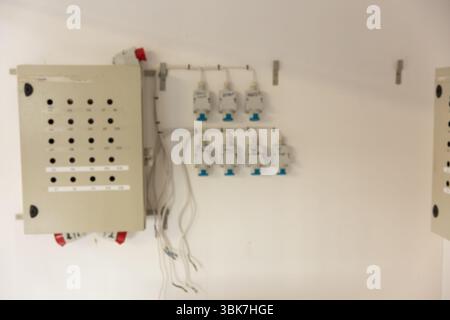 Flat design is showing beige electrical control panel on white wall with six modules and cables Stock Photo