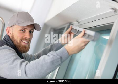 young man installing window blinds Stock Photo