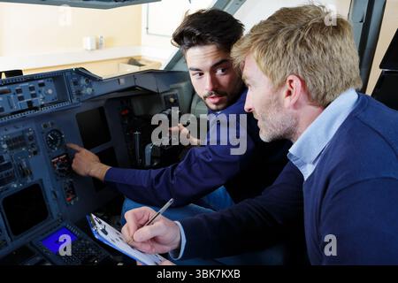 engineers working in plane cockpit Stock Photo