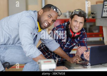 two modern mechanics using a laptop Stock Photo