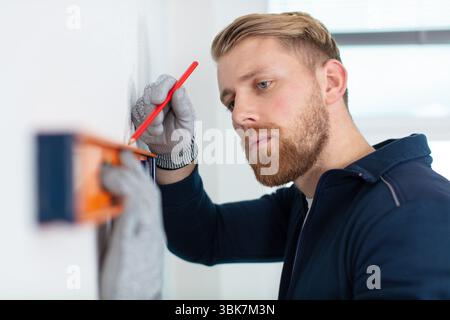 construction worker using spirit level and pencil Stock Photo