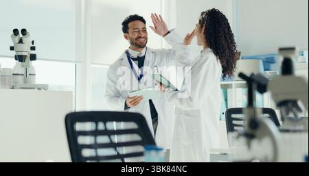 Science, people or high five with tablet in lab for clinical trial success, test results and goals. Scientist, teamwork or celebration for medical Stock Photo