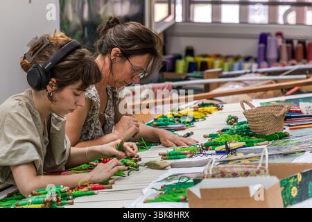 Weavers Margot and Aurelie at a flat loom (basselisse), as used in traditional tapestry making. Cité internationale de la tapisserie in Aubusson Rue Williams Dumazet, Aubusson, Nouvelle-Aquitaine, France Stock Photo
