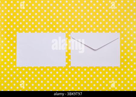 Two white envelopes on a yellow with white polka dots background with copy space Stock Photo
