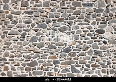 Wall constructed with various natural stones as background Stock Photo