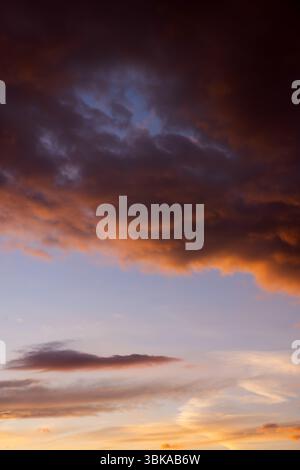 Dramatic sky with orange and dark clouds after storm Stock Photo
