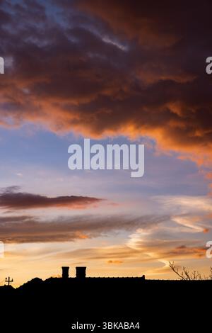 Dramatic sky with orange and dark clouds after storm Stock Photo