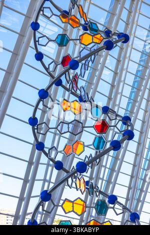 Human DNA helix made out of glass against blue sky closeup Stock Photo