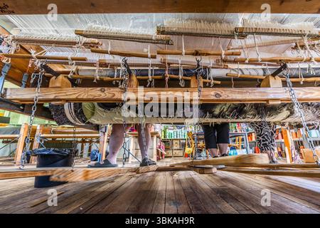 A look beneath the flat loom (basselisse) on which three weavers from the Robert Four workshop in Aubusson are creating Françoise Petrovitch's tapestry 'Hommage à George Sand' to mark the 150th anniversary of George Sand's death. Rue Madeleine, Aubusson, Nouvelle-Aquitaine, France Stock Photo