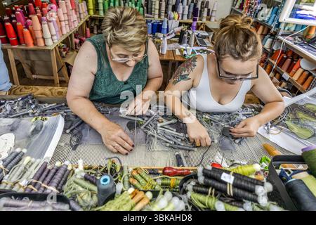 Two weavers from the Robert Four weaving mill in Aubussson surrounded by wool yarns and shuttlecocks in many shades of colour for the tapestry 'Hommage à George Sand' by French artist Françoise Petrovitch. Rue Madeleine, Aubusson, Nouvelle-Aquitaine, France Stock Photo